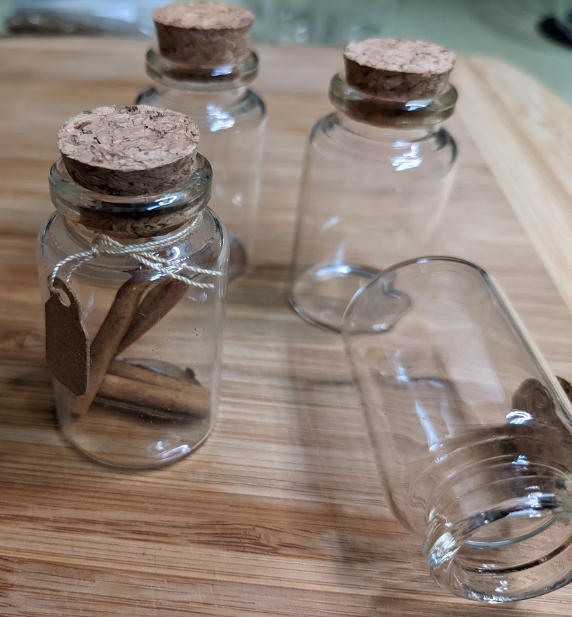4 glass vials, one with casia sticks