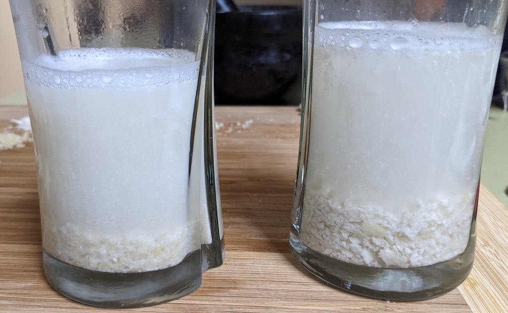 2 glasses containing ground almonds and white colored water