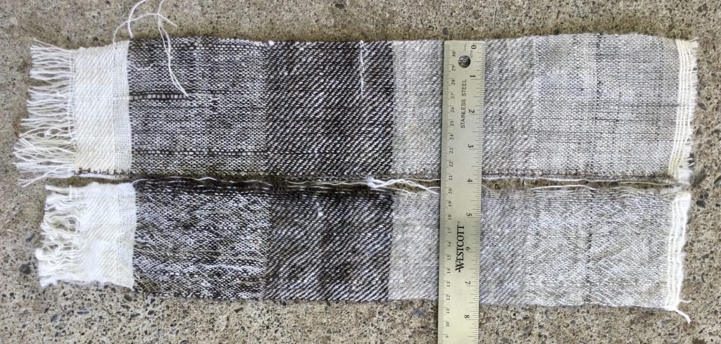 Sample has been cut in two, laying side by side with a ruler across the both of them. One half has been washed and shrunk.