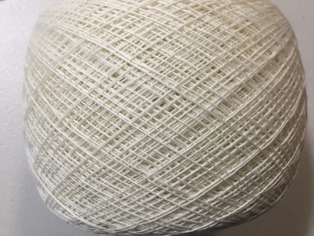 close up of a wound ball of single fine spun white wool.