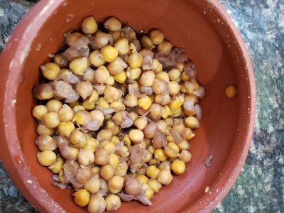 A dish of chickpeas in sauce served in a replica Roman dish