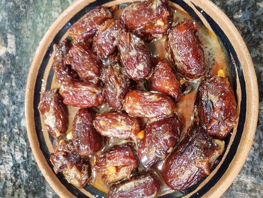 A dish of candied dates stuffed with pine nuts and served in a replica Roman dish
