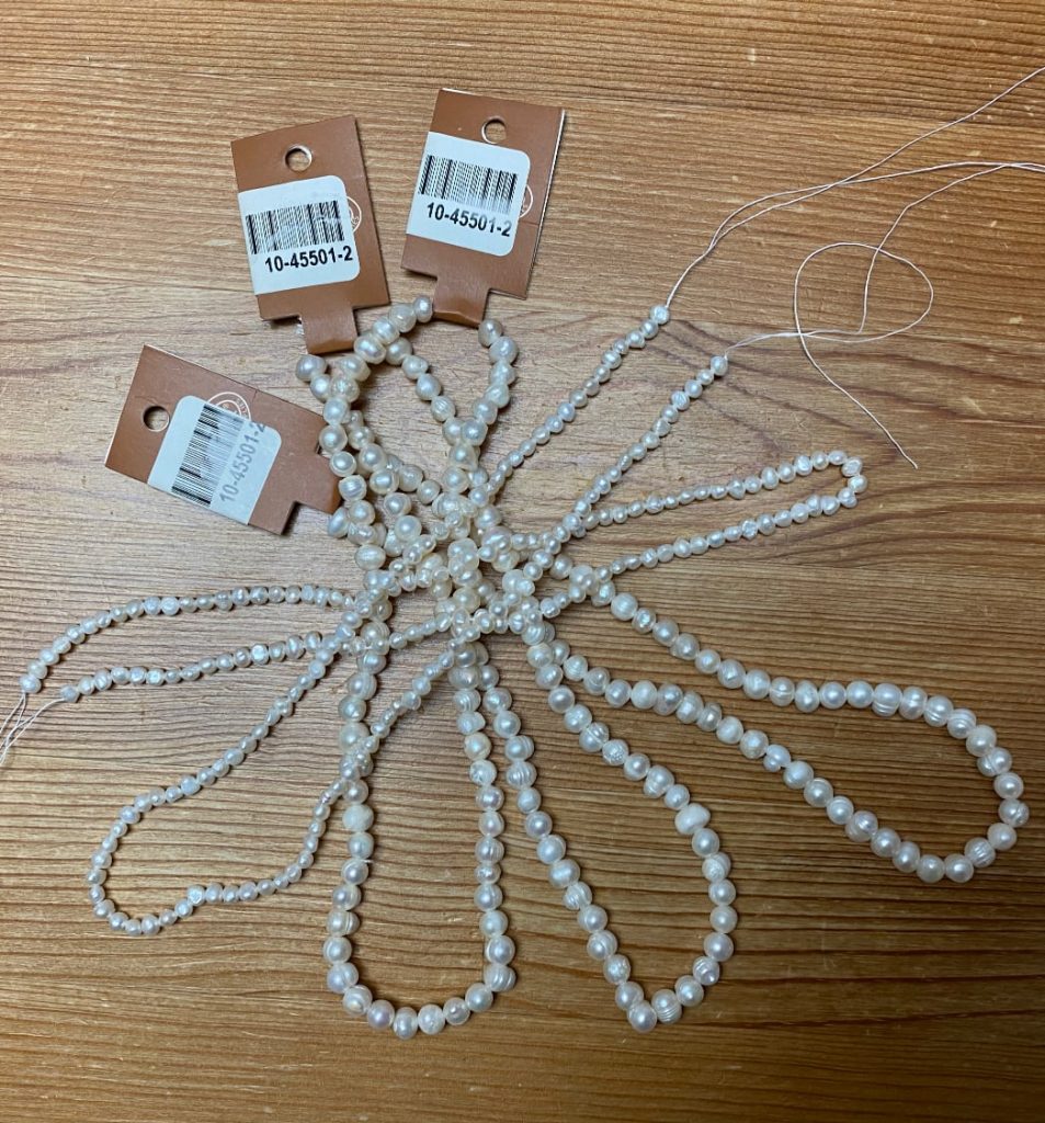 Five strings of freshwater pearls on a wooden table