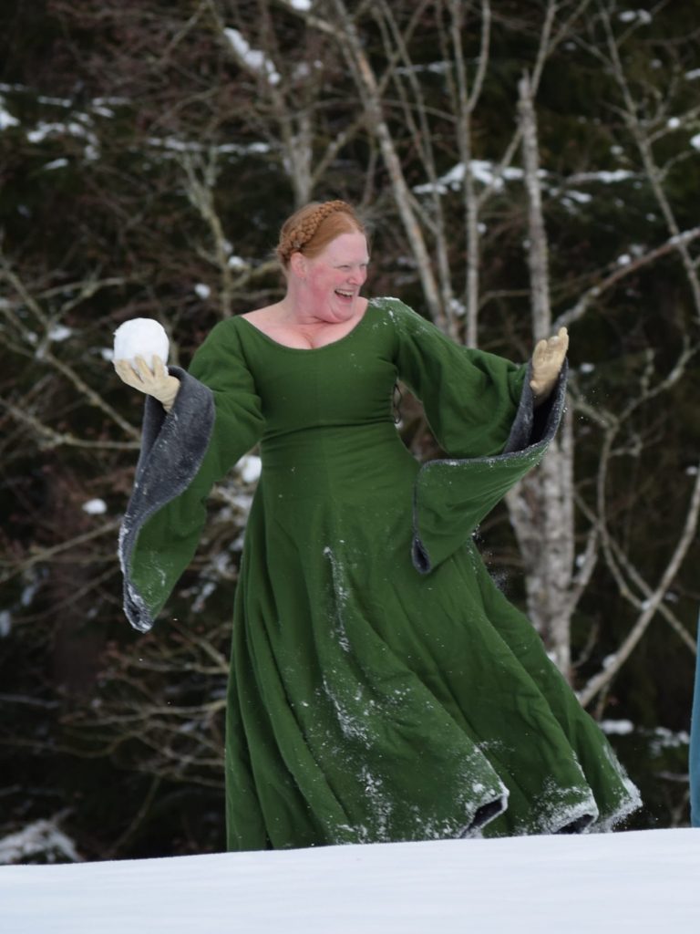 Lady in green dress throwing a snowball